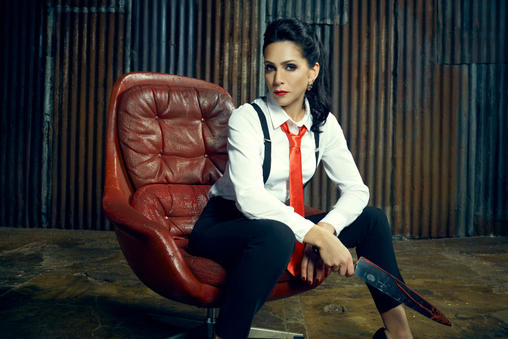 Emily Booth sitting on chair with knife