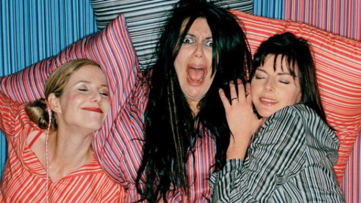 Three women in stripey clothes making silly faces