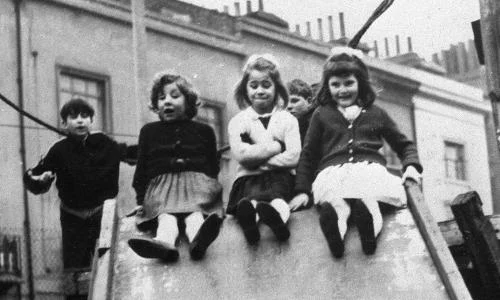 Group of children playing in a playground in black and white in the 1960s