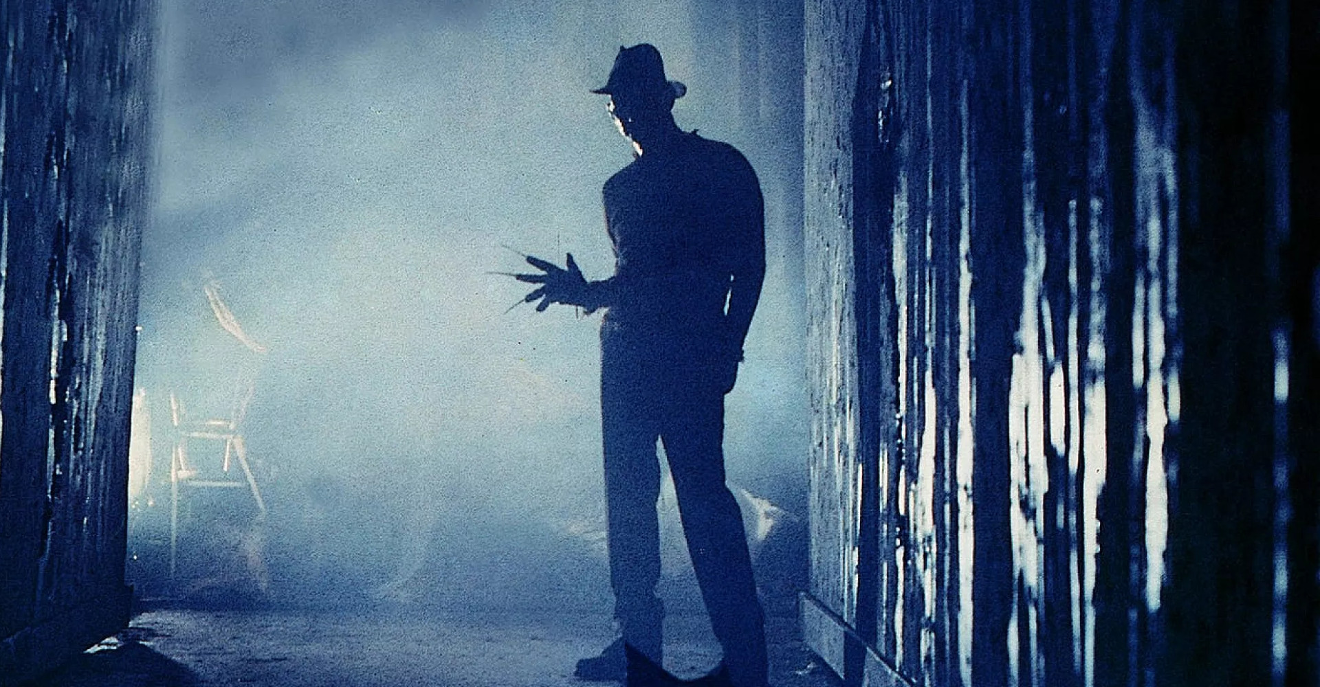 Freddy Kreuger man in dark alleyway with hat and pointy fingers