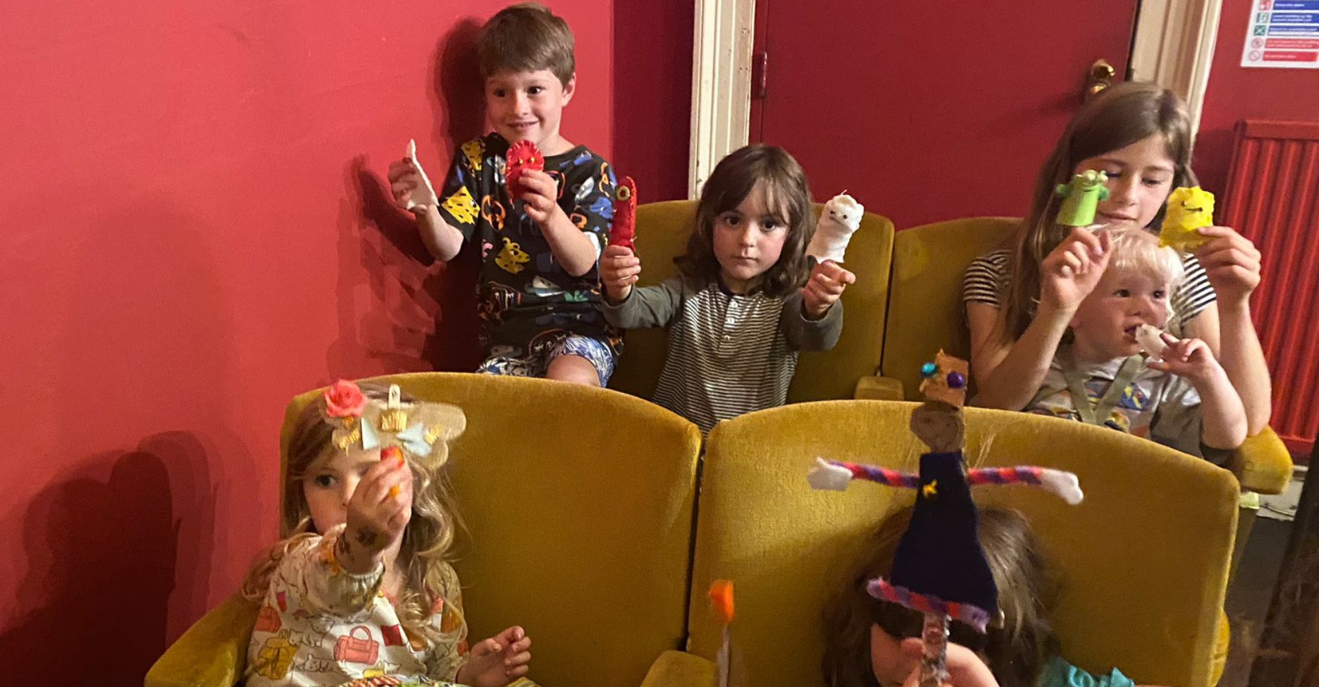 Group of children in cinema holding puppets