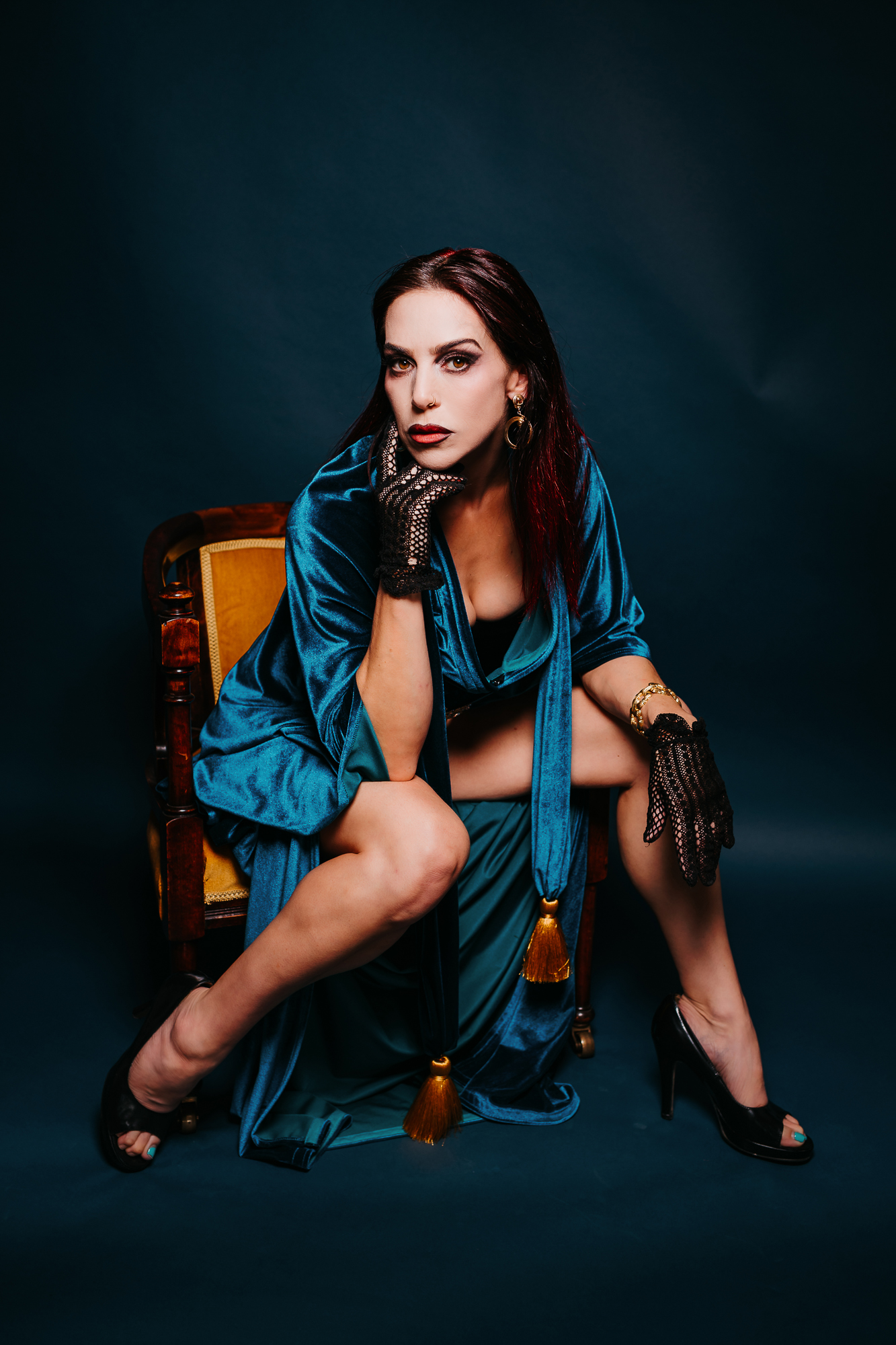 Emily Booth dressed in sexy garments, sitting on chair